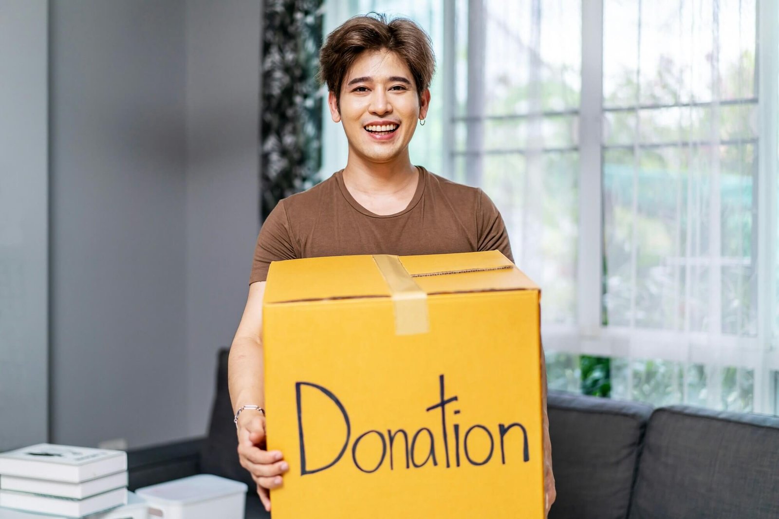 Happy Volunteer Asian Man Holding A Donate Box For Giving Smiling Male Working At Charity Center