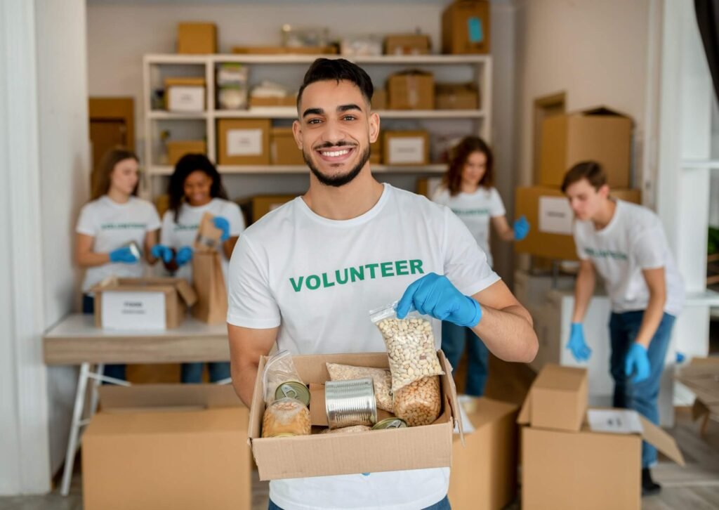 Young Arab Volunteer Working At Charity Center Holding Food Donation Box And Smiling To Camera 1024x726
